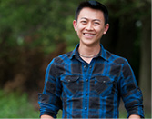 A student standing in front of trees