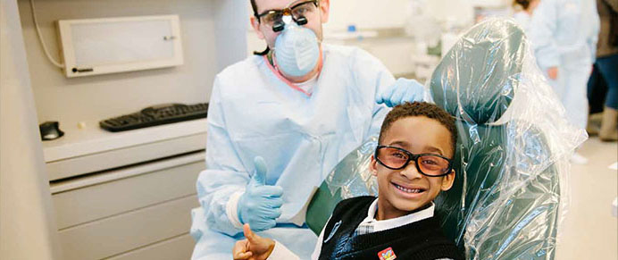 A child in a dental chair receiving a cleaning