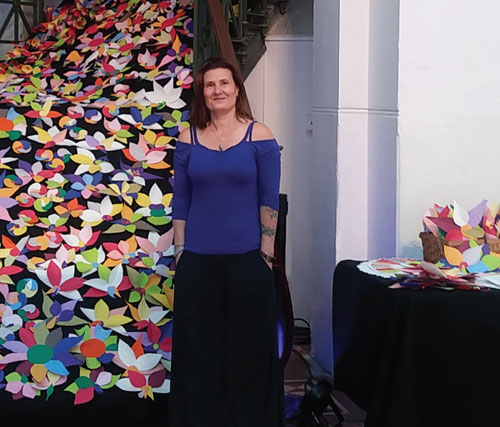 Stevie Famulari standing in front of her art exhibit