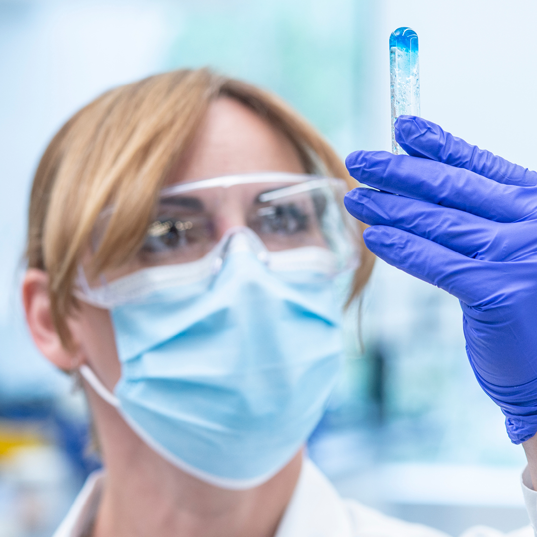 Lab technician holding up a test tub