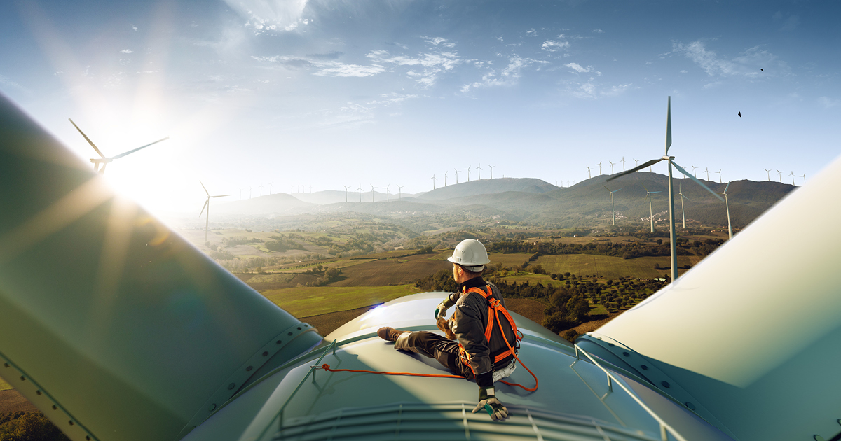 Technician sitting on top of a wind turbine