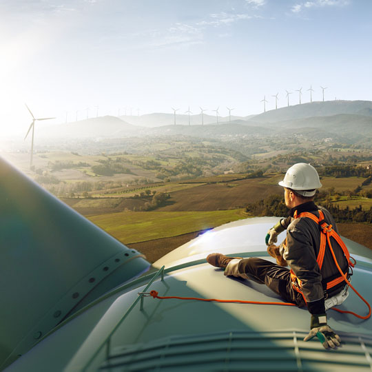 Technician sitting on top of a wind turbine